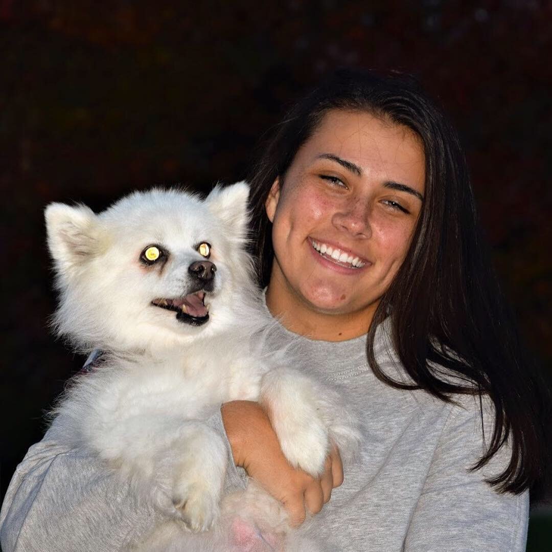 Image of Maddie Drescher smiling holding a white dog
